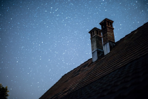 a couple of chimneys under a starry sky