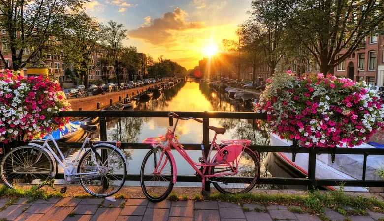 two bikes and flowers on the bridge of amsterdam canal
